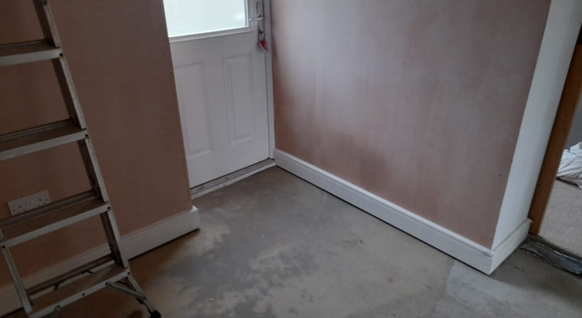 Garage conversion in progress in Staffordshire — freshly plastered walls, new skirting boards and door fitted by DJF Building